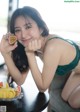 A woman sitting at a table with a plate of fruit.