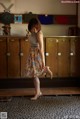 A woman standing in front of a row of lockers.