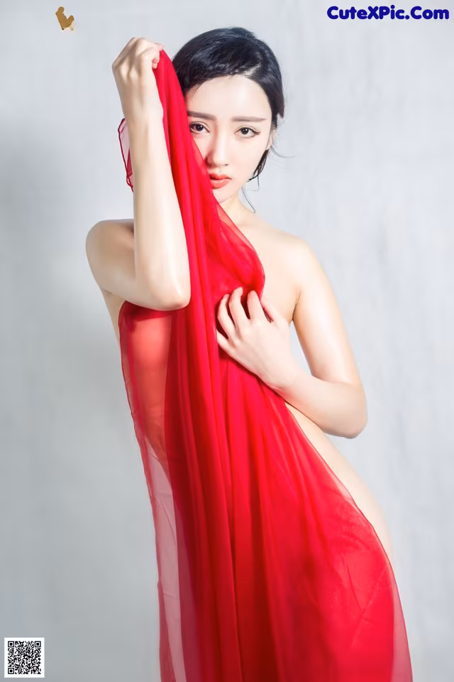 A woman in a red dress is posing for a picture.