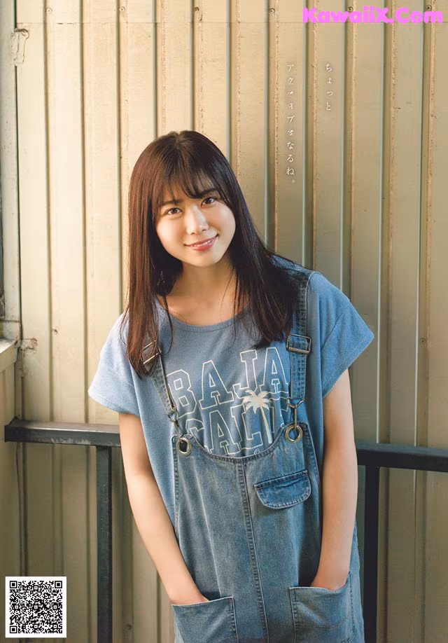 A young woman standing in front of a metal wall.