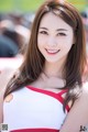 A woman in a red and white dress posing for a picture.