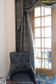 A blue chair sitting in front of a window in a room.