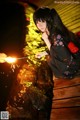 A woman in a kimono holding a sparkler on a wooden bridge.