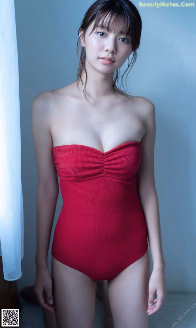 A woman in a red bathing suit posing for a picture.