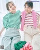 Two young women sitting next to each other on a bed.