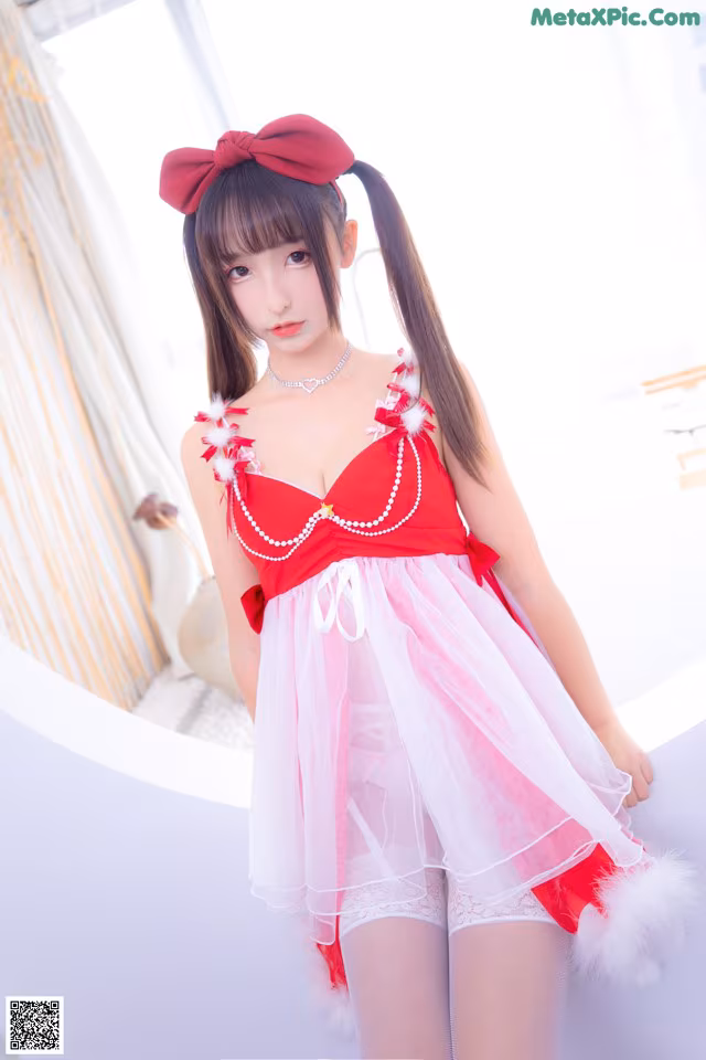 A woman in a red and white dress posing for a picture.