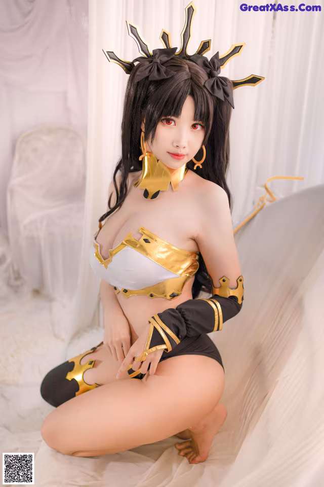 A woman in a black and gold outfit sitting on a bed.