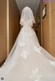 A woman in a wedding dress walking down a hallway.