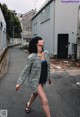 A woman walking down a street in a black and white coat.