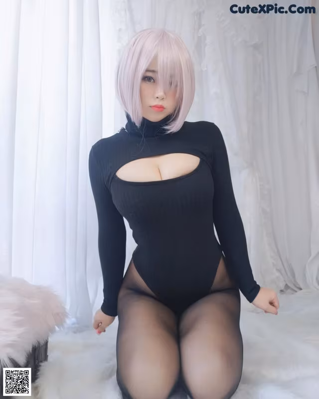 A woman in a black bodysuit sitting on a white fur rug.