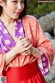 A woman in a pink and purple kimono posing for a picture.